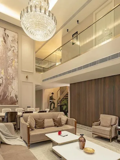 We believe in creating spaces with presence. This double-height drawing room uses vertical volume, a statement chandelier, and a neutral palette to create an atmosphere of classical opulence and refined comfort.