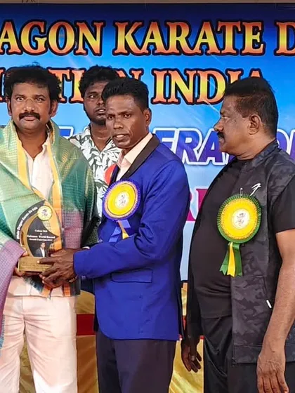 Presenting an award to a fellow master at a prestigious award and belt grading ceremony.