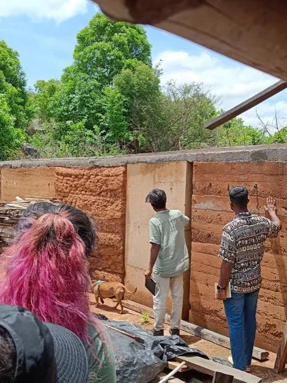 My team examining the details of a rammed earth wall at a construction site. This hands-on learning is invaluable.