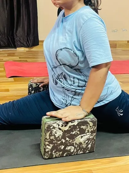 A close-up of using blocks in a split variation. This technique allows the practitioner to control the depth of the stretch and build confidence in the pose.