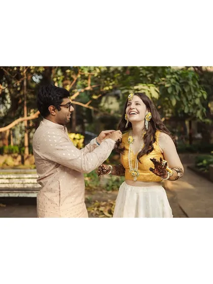 A candid moment of laughter during Amanda and Ankur's mehendi ceremony. He playfully adjusts her hair, and her resulting smile is completely genuine and heartwarming.