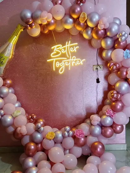 This "Better Together" neon sign is a lovely centerpiece for any couple's celebration. It's paired here with a pink and rose gold circular balloon arch, perfect for an engagement, anniversary, or romantic party.