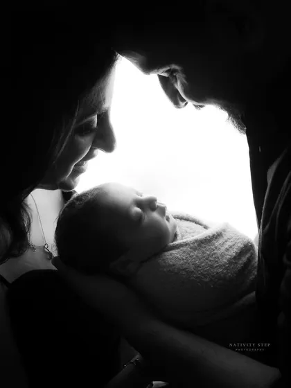 There is something magical about the first few days with your newborn. This artistic black and white silhouette captures the profound love and connection of new parents holding their baby.