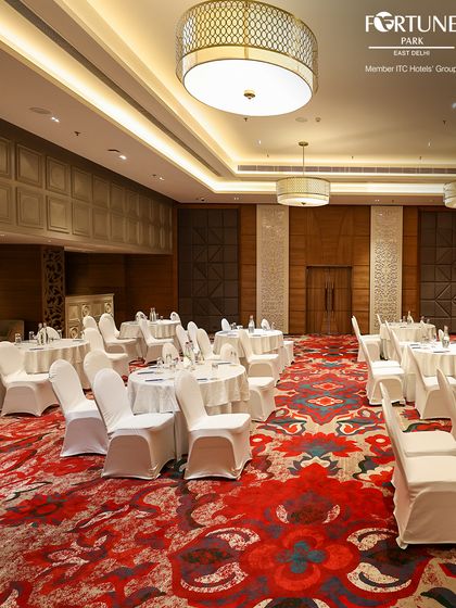 The versatility of my event spaces allows for various layouts, including this theater-style setup for a conference. The vibrant carpeting and sophisticated lighting add a touch of class to any professional event.