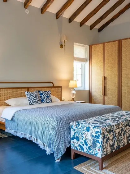 This bedroom in a Goan villa captures a different mood, blending rustic elegance with a modern, airy aesthetic. We used natural materials like oak and rattan, paired with a serene color palette and patterned textiles, to create a personal retreat that feels connected to its coastal setting.