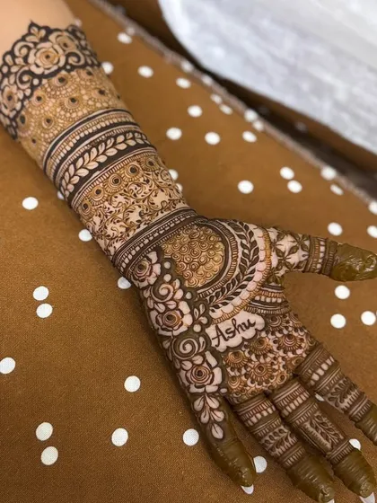 I love adding personal touches to make your bridal henna truly yours. For this engagement design, I seamlessly integrated the name 'Ashu' into the floral and paisley patterns on the palm.