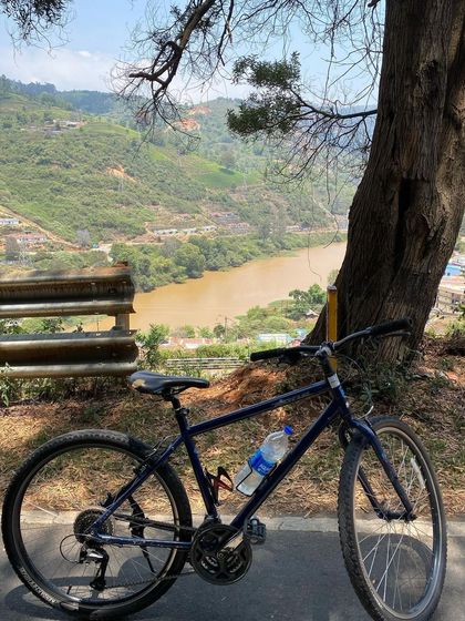 A moment of rest with a view of the river. Even on challenging mountain tours, there are always serene spots to pause, rehydrate, and soak in the scenery.