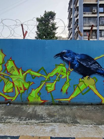 Another angle of the collaborative blue wall, showing how different artists' styles can come together to create a single, dynamic piece of street art.