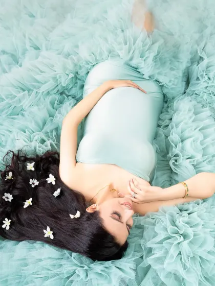 A different perspective of our mint green tulle setup, this overhead shot captures the mother-to-be in a peaceful, dream-like pose.