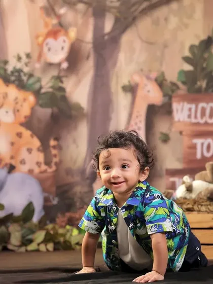 A candid crawling shot of the birthday boy, smiling during his jungle-themed first birthday session.