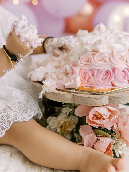 A close-up of a baby's hand in the cake. It's all about the details and the sensory experience of a first birthday.