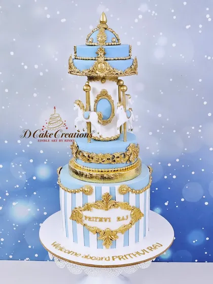 A studio shot of the blue and gold carousel cake, showcasing the intricate gold details and the delicate craftsmanship of the edible carousel.