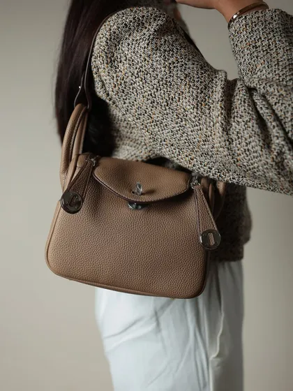 The Linde Medium bag worn as a shoulder bag. The handle is long enough to sit comfortably on the shoulder for a sophisticated, hands-free look.