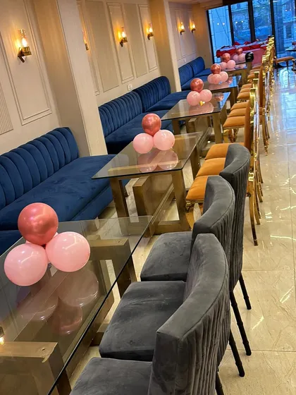 The seating area for an anniversary party, with simple balloon centerpieces on each table to match the overall theme.
