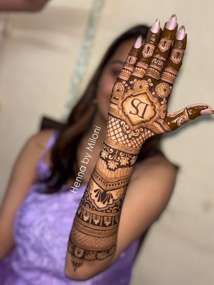 A modern bridal design extending up the arm, featuring a personalized initial monogram. The combination of checks, floral bands, and bold initials creates a unique look.