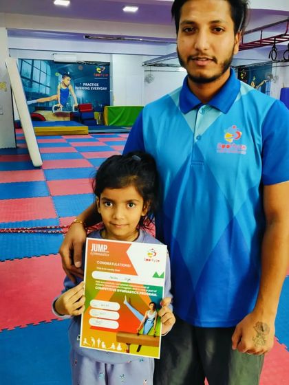 This young gymnast proudly holds her "JUMP" program certificate.