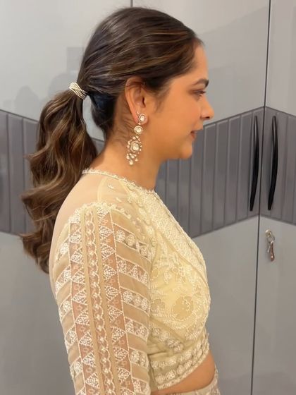 A simple and chic ponytail with a decorative tie, perfect for a bridesmaid or a wedding guest.