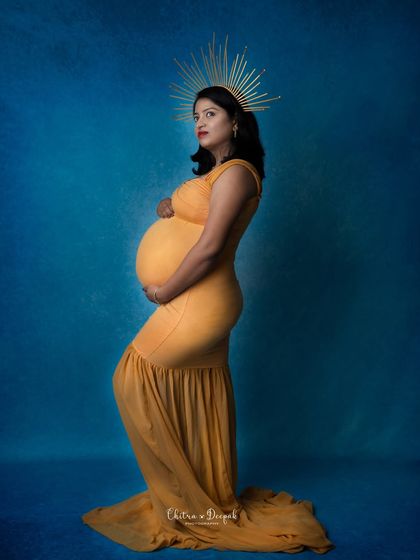 A bold and artistic choice. The bright yellow gown and golden halo create a stunning contrast against the deep blue background.