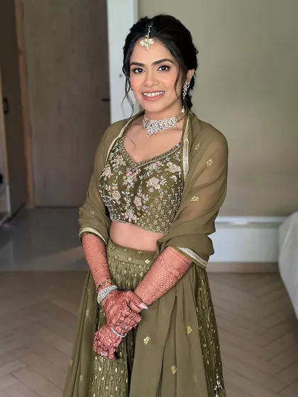 A happy bride ready for her Mehendi. The makeup is minimal and fresh, with a focus on glowing skin and softly defined eyes.
