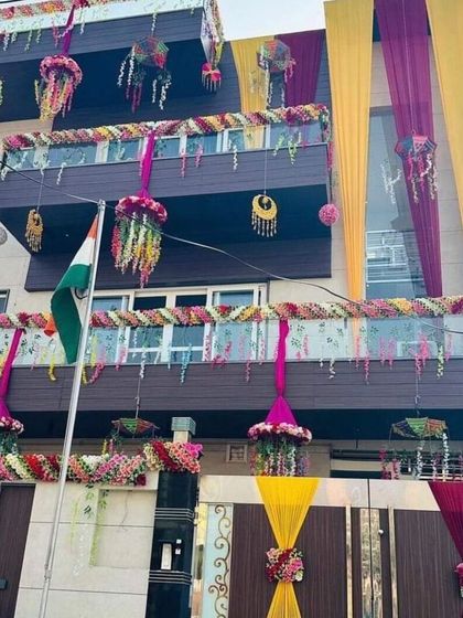 A grand house decoration with multiple layers of drapes, hanging floral baskets, and traditional ornaments. This creates a rich and festive look for a big celebration.