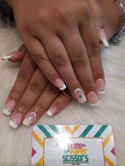 A classic French manicure with a sparkling twist. I added a thin silver glitter line to separate the white tip from the nude base and placed a tiny star gem on the accent nails.