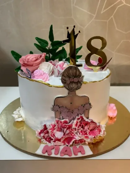 An elegant cake for an 18th birthday. The design features a beautiful illustration, fresh-looking sugar flowers, and a delicate fabric effect on the dress.