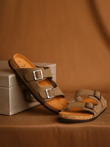A clean, simple product shot of two-strap sandals against a neutral brown background. This minimalist setup is perfect for e-commerce, focusing entirely on the product's design and color.