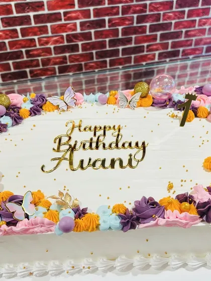 A beautiful sheet cake decorated with a frame of colorful buttercream flowers in pastel shades.