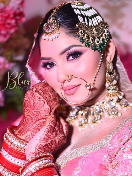 Another angle of this beautiful pink bridal look. You can see the detail in the mehndi and how the makeup tones are chosen to complement the bride's entire ensemble, from her lehenga to her bangles.