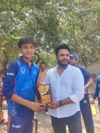 A proud player holding his award, with a table full of trophies in the background. This is a visual reminder of what we can achieve as a team.
