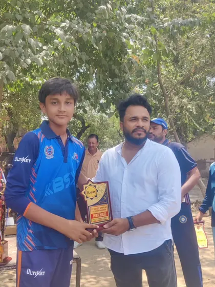 A proud player holding his award, with a table full of trophies in the background. This is a visual reminder of what we can achieve as a team.