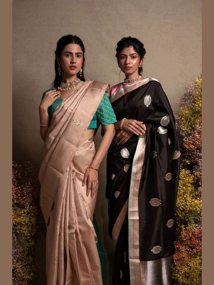 A comparison of two sarees: a subtle peach Kanjivaram and a classic black Banarasi with silver butis.