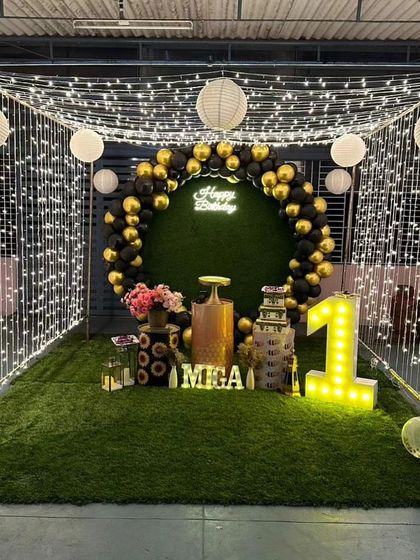 This is a duplicate of ID 24. An enchanting outdoor birthday setup for a first birthday. We created a magical canopy of fairy lights and paper lanterns over an artificial grass patch, complete with a balloon ring and marquee number.