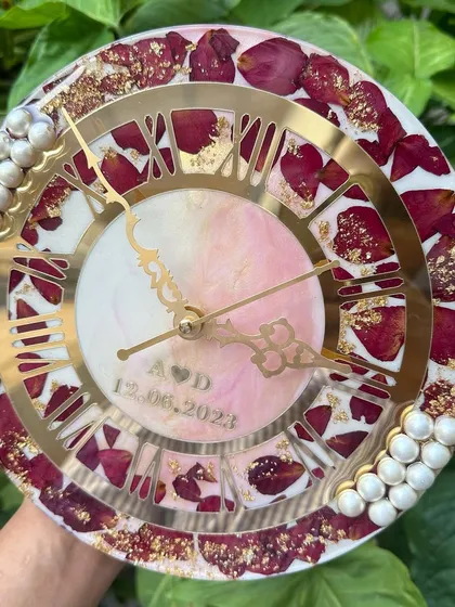 This image shows the clock held up, giving a sense of its size and how the pearl accents on the side catch the light.