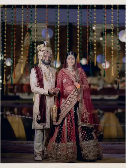 A classic portrait of the couple against a backdrop of hanging floral decorations.