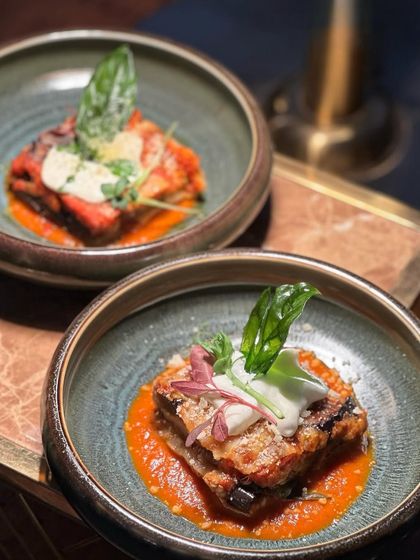 Our beautifully plated Eggplant Parmigiana. This classic Italian dish, with its layers of tender eggplant, rich tomato sauce, and melted cheese, is pure comfort food.