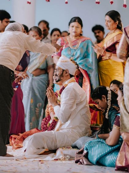 The groom receiving blessings from an elder during the wedding ceremony, a moment of respect and tradition.