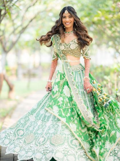A joyful, twirling shot of our bride in her green lehenga. The makeup is designed to look flawless even in motion, ensuring she looks perfect all day long.