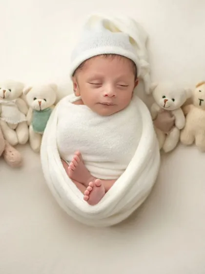 A wide view of the teddy bear lineup, with the sleeping newborn as the star of the show.