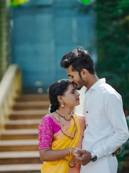 A tender moment between the couple. The groom kisses the bride's forehead in this beautiful, emotional shot showcasing their traditional wedding attire.