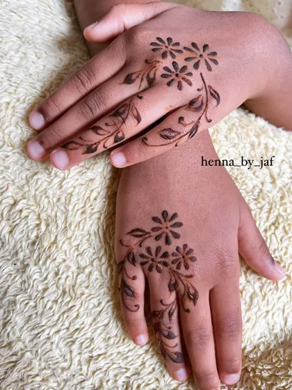 A simple and sweet floral design for a child, with a small spray of flowers and leaves on the back of each hand.