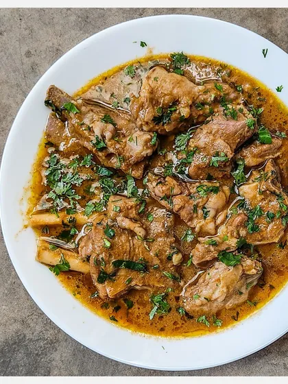 A close-up of my Bannur Mutton Saaru, showing the tender, bone-in pieces of lamb in a luscious, aromatic gravy, garnished with fresh coriander.