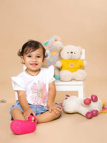 A happy toddler sitting with her stuffed animal friends. This simple and sweet portrait captures the innocence and joy of childhood.