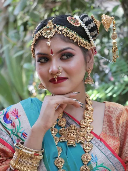 A thoughtful pose that gives a closer view of the layered necklaces and the detailed makeup.