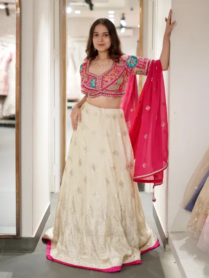 This lehenga may leave you awestruck. The combination of a cream skirt and a brightly embroidered pink blouse is simply stunning.