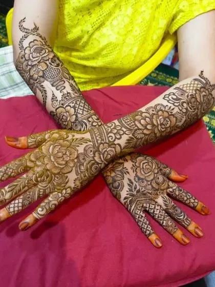A beautiful example of full bridal henna, where both hands are adorned with matching floral and jaal patterns. This symmetry is key for stunning photographs of your hands together.