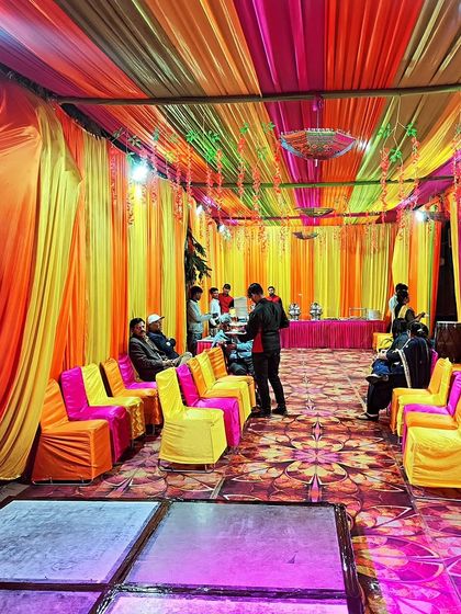 A wide shot of the tent interior, showing the seating arrangement and the warm, festive lighting perfect for an evening function.