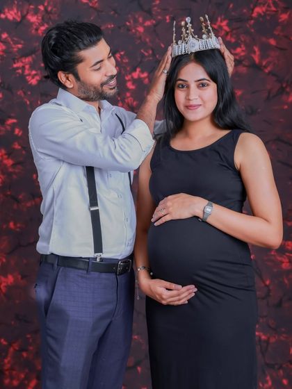 A loving partner crowns the mother-to-be in this sweet studio portrait. It's a beautiful gesture that celebrates her as the queen of their growing family.