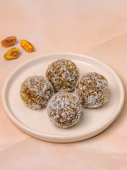 Healthy date and coconut energy balls on a simple white plate. The light and airy photography style makes this healthy snack look delicious and clean.