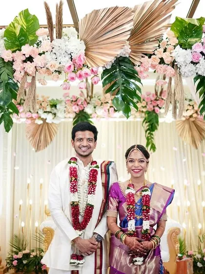A classic portrait of the bride and groom at their wedding mandap. The stunning floral decor provides a perfect frame for this timeless shot of the happy couple.
